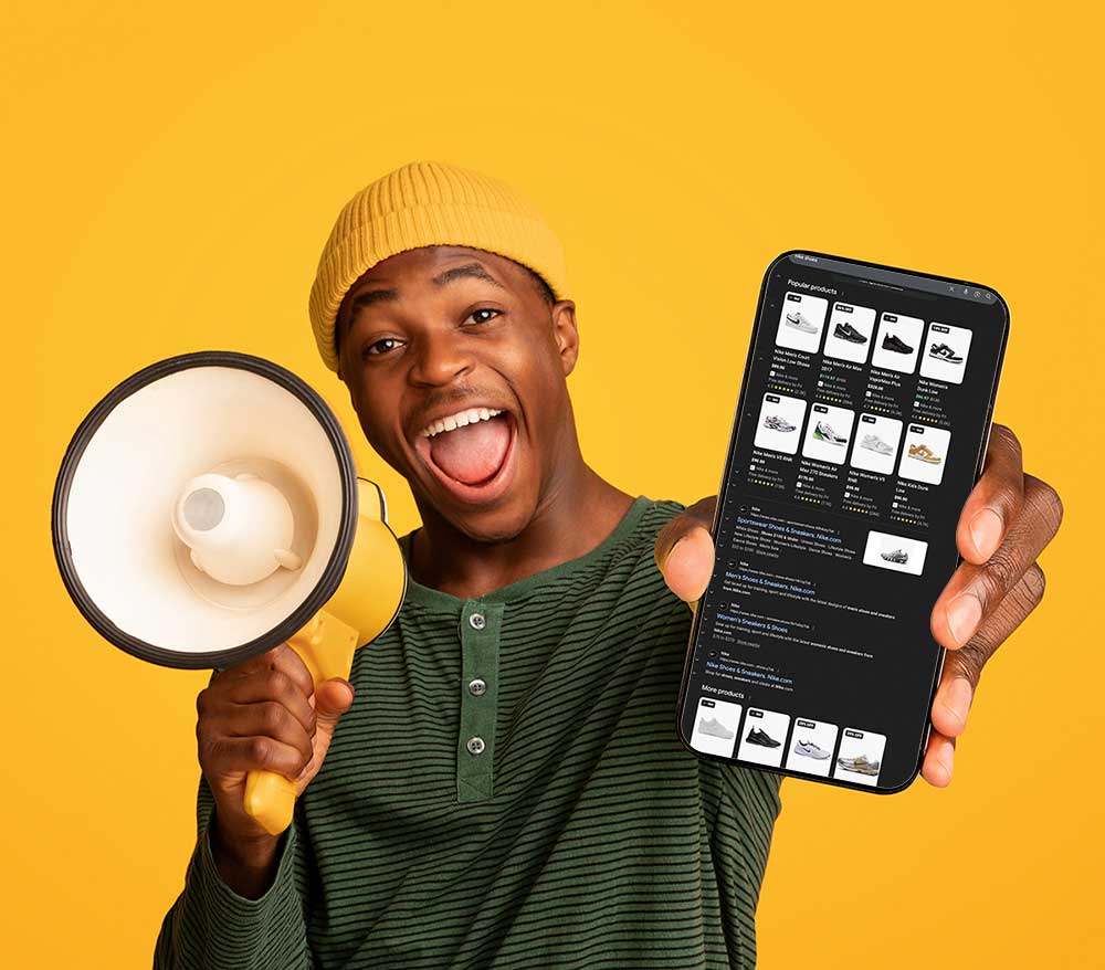 cheerful black guy holding a megaphone and showing google ads on his smartphone